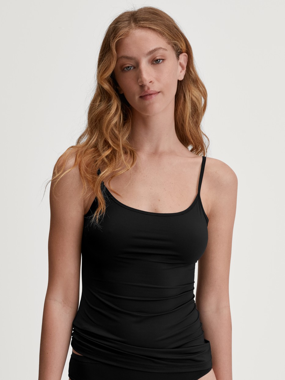 La modella / Il modello Donna indossa Top con spalline in Cotone di colore Nero, Tinta unita, della serie Sleek Skin di CALIDA, Vista frontale