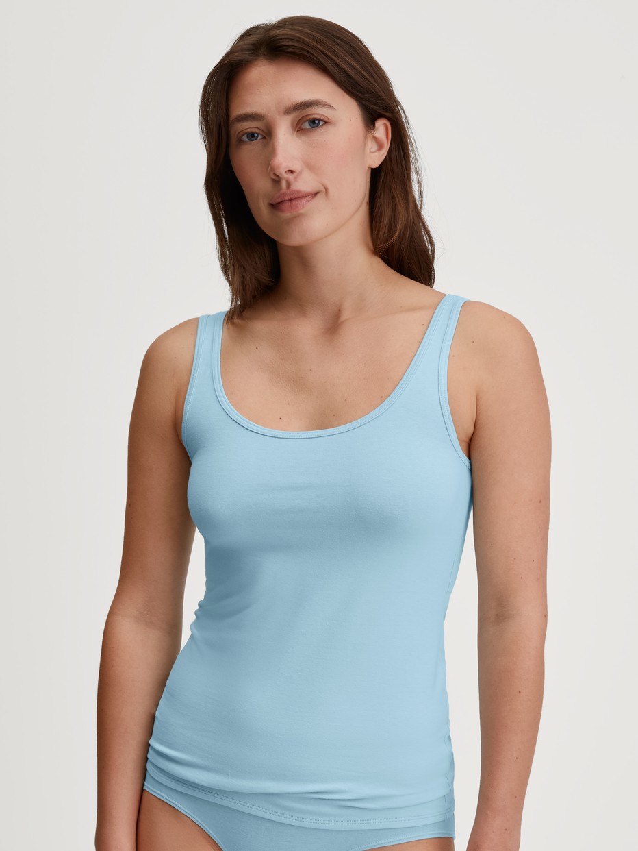 Women model is wearing Tank top made of Cotton in Blue, Unicoloured from the Essential Cotton series by CALIDA, Front view