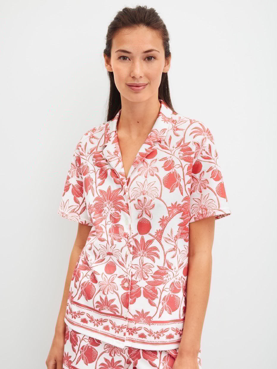 Damen-Model trägt Kurzarm-Shirt mit Knöpfen aus 100% Baumwolle in Orange, Floral aus Serie Favourites Beach von CALIDA, Vorderansicht