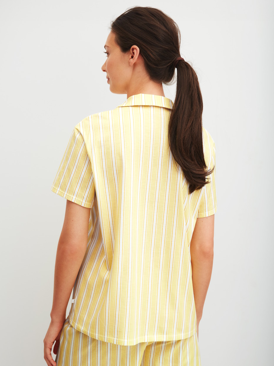 Women model is wearing Short-sleeved shirt with buttons made of 100% Cotton in Yellow, Striped from the Favourites Ocean series by CALIDA, Back view