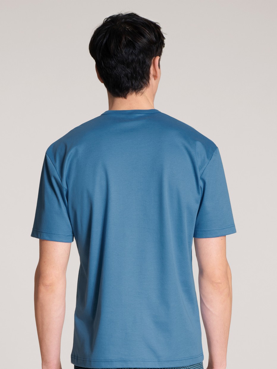 Herren-Model trägt Kurzarm-Shirt aus 100% Baumwolle in Blau, Einfarbig aus Serie Remix Xtra von CALIDA, Rückansicht