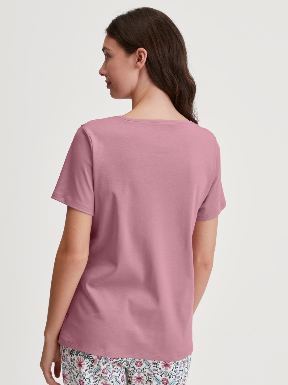 Women model is wearing Short-sleeved shirt made of 100% Cotton in Pink, Unicoloured from the Favourites Botanic series by CALIDA, Back view