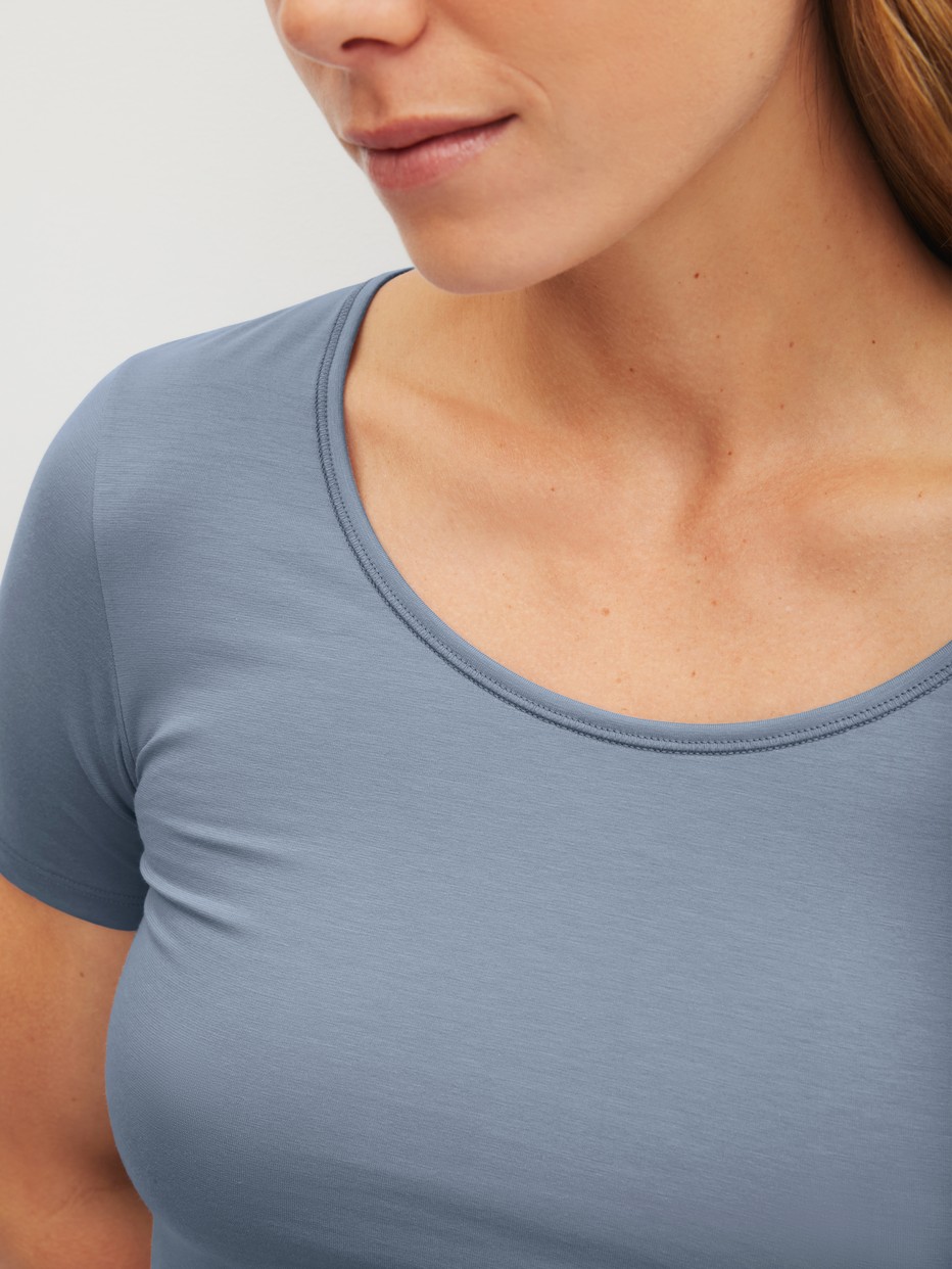 Damen-Model trägt T-Shirt, Rundhals aus Baumwolle in Blau, Einfarbig aus Serie Natural Comfort von CALIDA, Detail