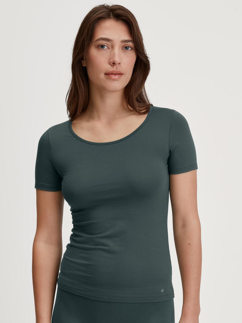 Damen-Model trägt T-Shirt, Rundhals aus Baumwolle in Grün, Einfarbig aus Serie Natural Comfort von CALIDA, Vorderansicht