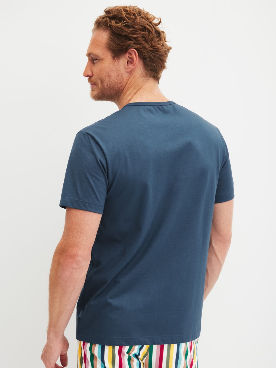 Herren-Model trägt Kurzarm-Shirt aus 100% Baumwolle in Blau, Einfarbig aus Serie RMX Sleep Holiday von CALIDA, Rückansicht