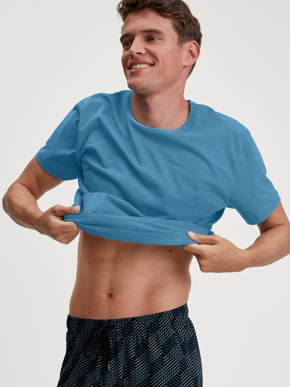 Herren-Model trägt Kurzarm-Shirt aus 100% Baumwolle in Blau, Einfarbig aus Serie RMX Sleep Leisure von CALIDA, Zusatzbild
