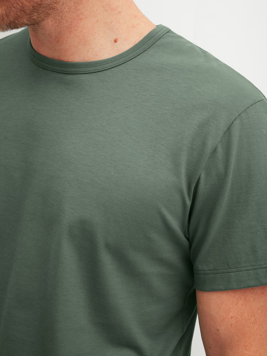 Herren-Model trägt Kurzarm-Shirt aus 100% Baumwolle in Grün, Einfarbig aus Serie RMX Sleep Leisure von CALIDA, Detail