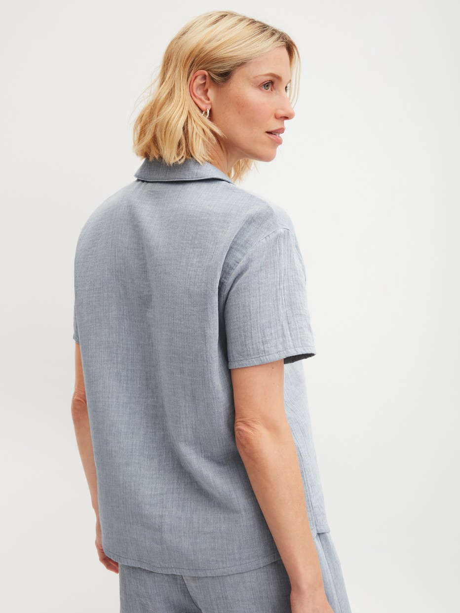 La modella / Il modello Donna indossa Camicia a maniche corte con bottoni in 100% cotone di colore Blu, Tinta unita, della serie Favourites Tiles di CALIDA, Vista posteriore