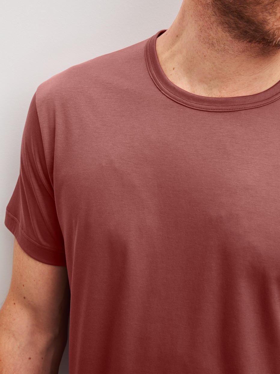 La modella / Il modello Uomo indossa Maglietta a maniche corte in Cotone di colore Arancione, Tinta unita, della serie RMX Sleep Superlight di CALIDA, Dettaglio