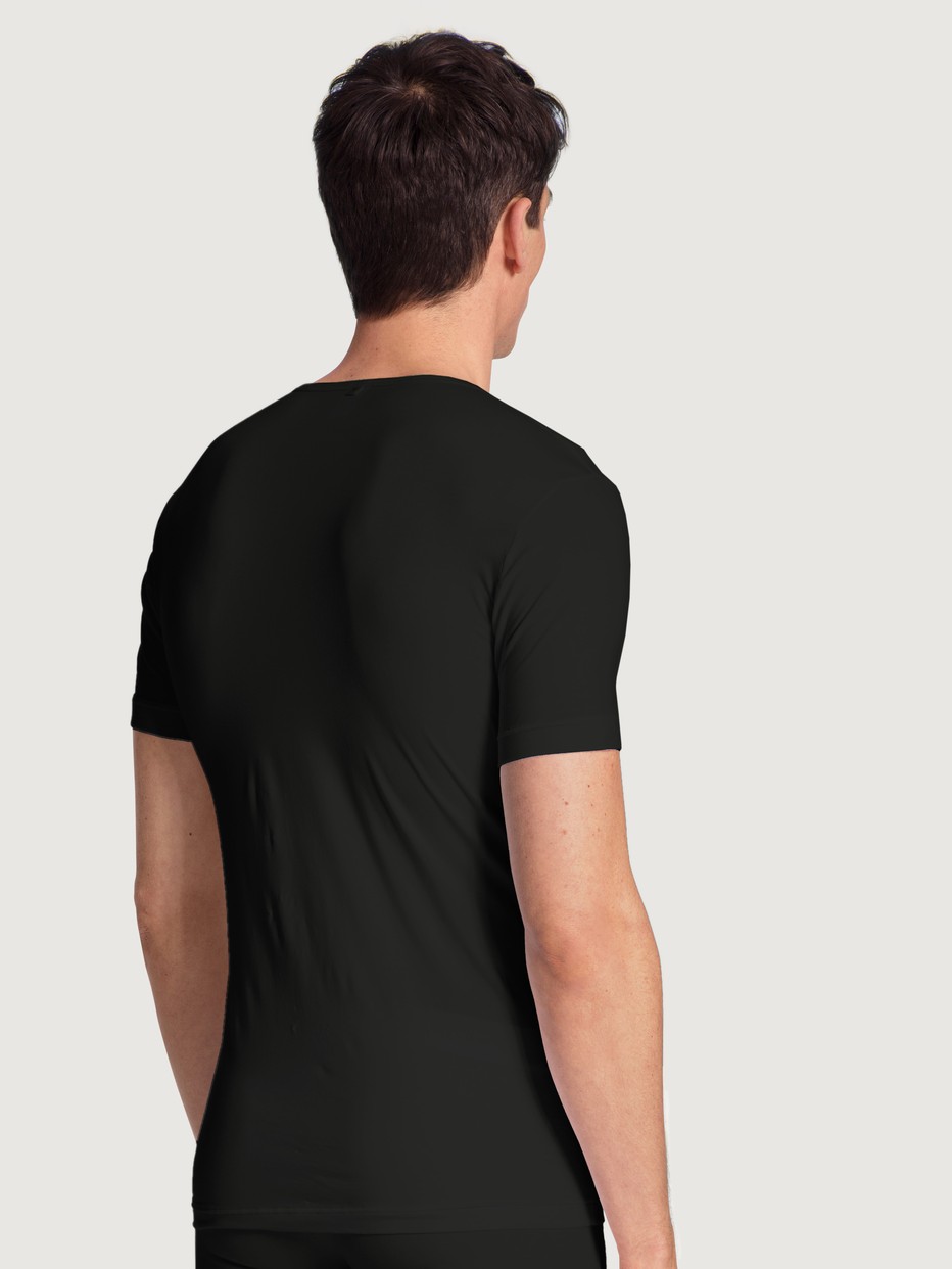 Men model is wearing T-Shirt made of Lyocell in Black, Unicoloured from the Focus series by CALIDA, Back view