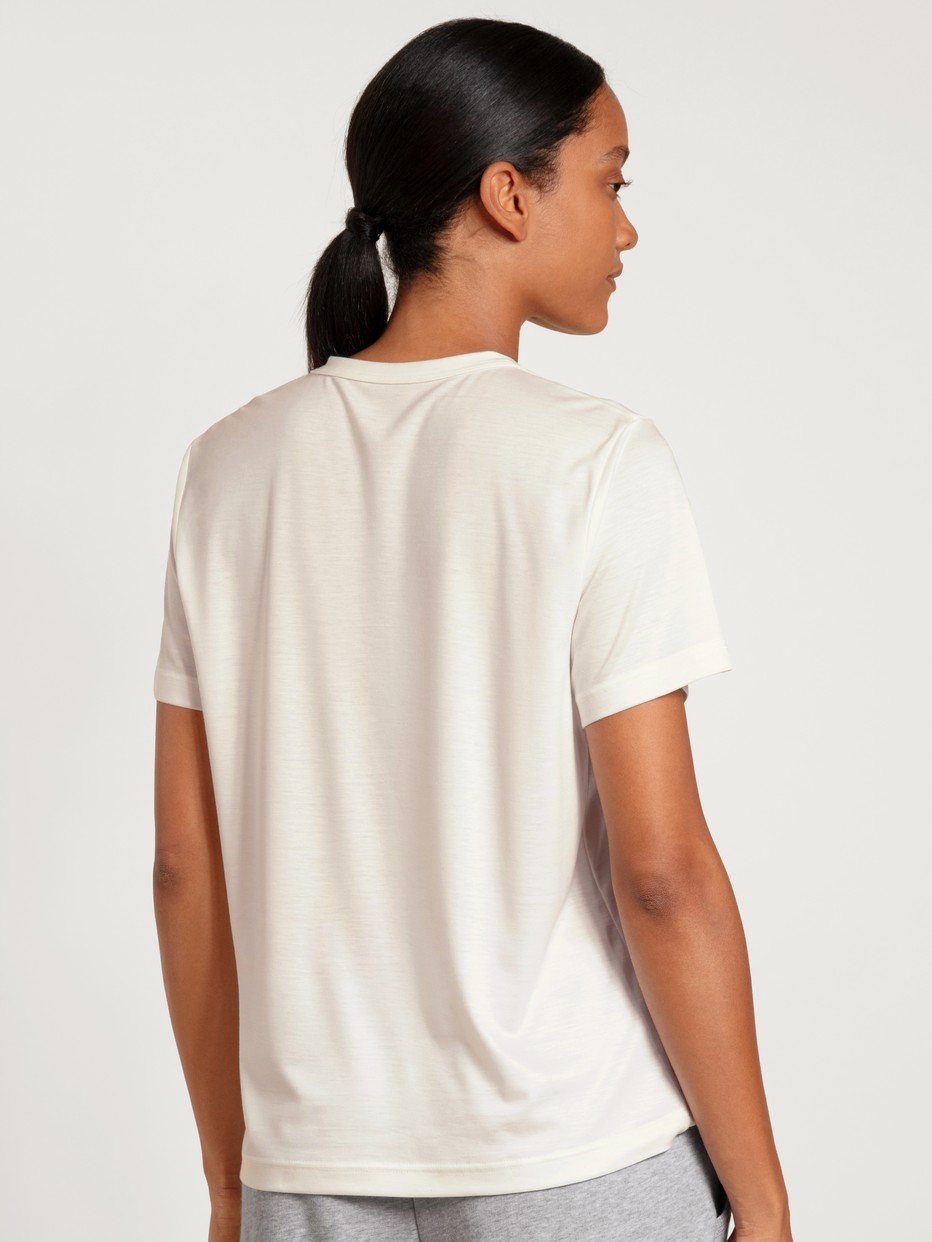 Damen-Model trägt Kurzarm-Shirt aus Modal in Weiß, Einfarbig aus Serie Lounge & Relax von CALIDA, Rückansicht