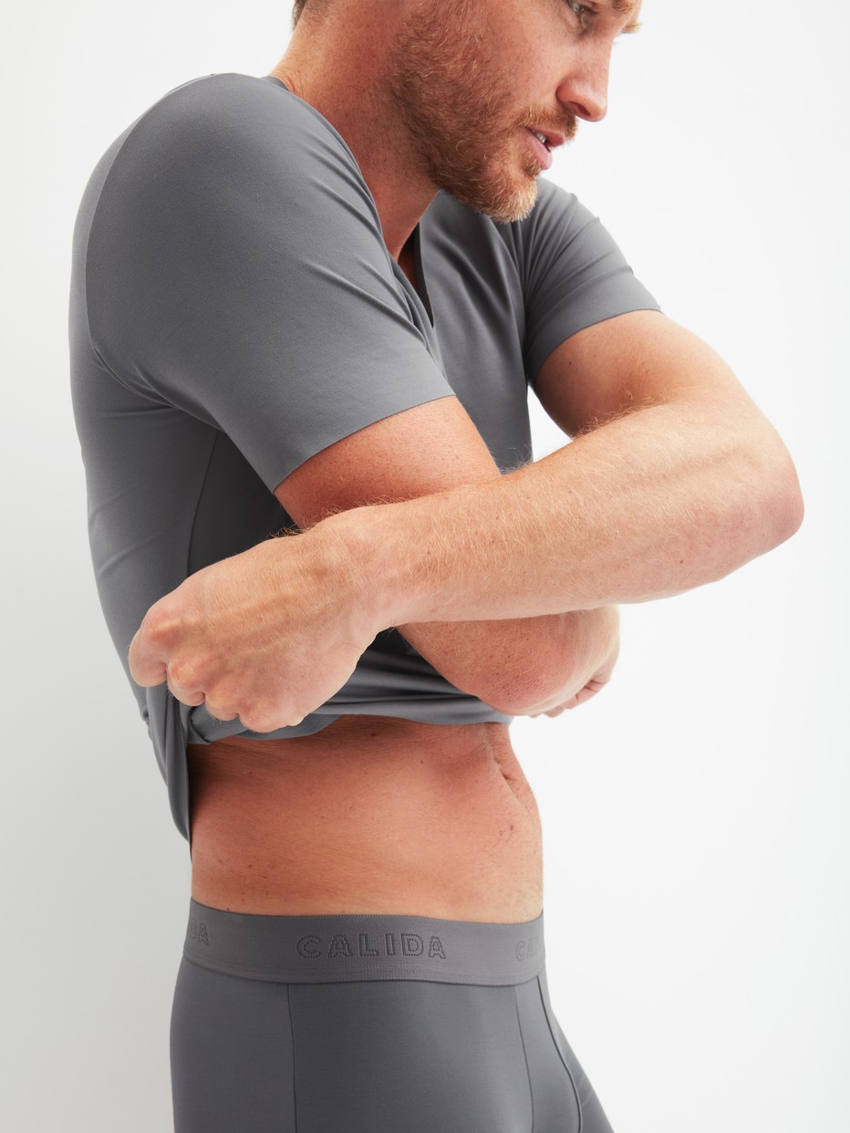 Herren-Model trägt Kurzarm-Shirt, V-Neck aus Modal in Grau, Einfarbig aus Serie Clean Line von CALIDA, Zusatzbild