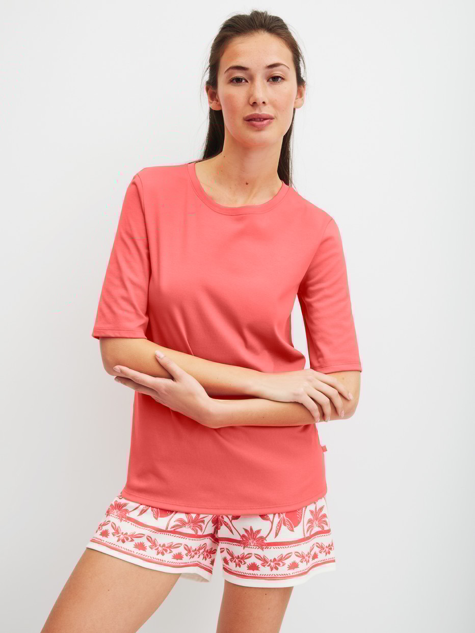 Women model is wearing Short-sleeved shirt made of 100% Cotton in Orange, Unicoloured from the Favourites Beach series by CALIDA, Outfit