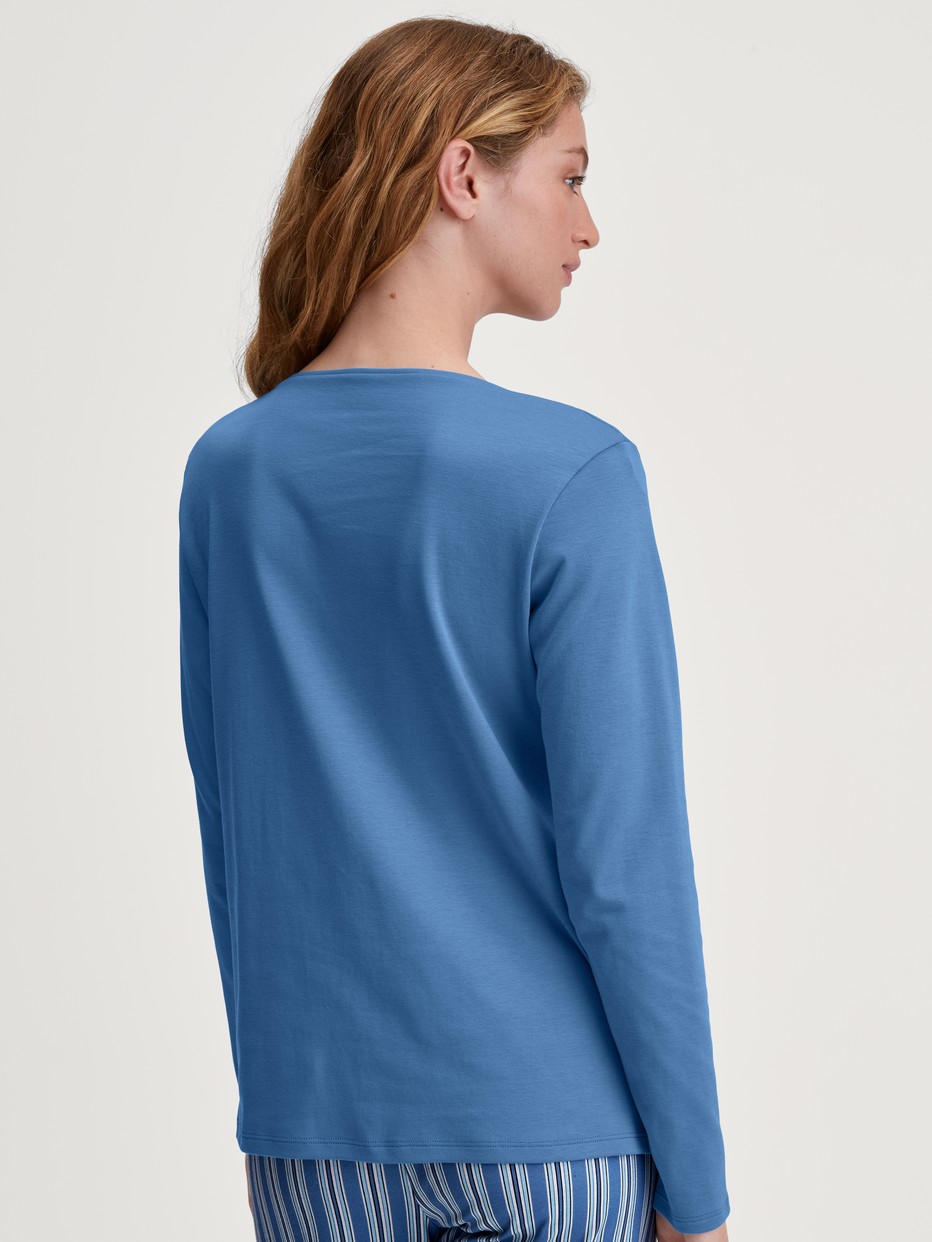 La modella / Il modello Donna indossa Camicia a maniche lunghe, scollo a V in 100% cotone di colore Blu, Tinta unita, della serie Favourites Journey di CALIDA, Vista posteriore