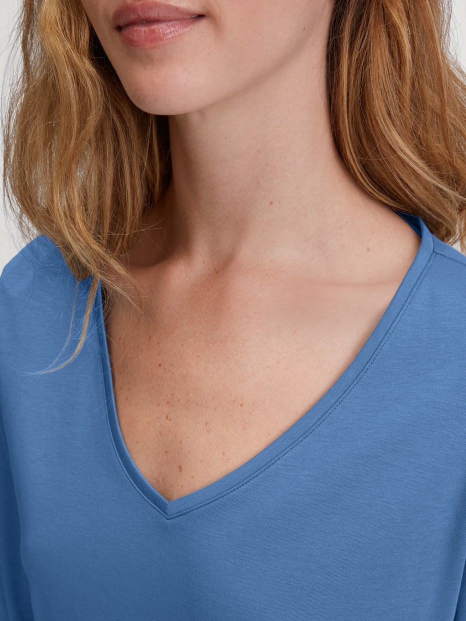 La modella / Il modello Donna indossa Camicia a maniche lunghe, scollo a V in 100% cotone di colore Blu, Tinta unita, della serie Favourites Journey di CALIDA, Dettaglio