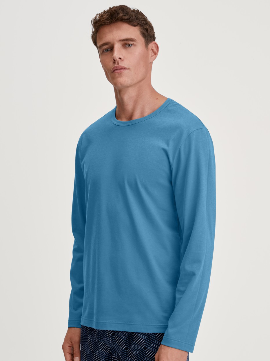 Herren-Model trägt Langarm-Shirt aus 100% Baumwolle in Blau, Einfarbig aus Serie RMX Sleep Leisure von CALIDA, Vorderansicht
