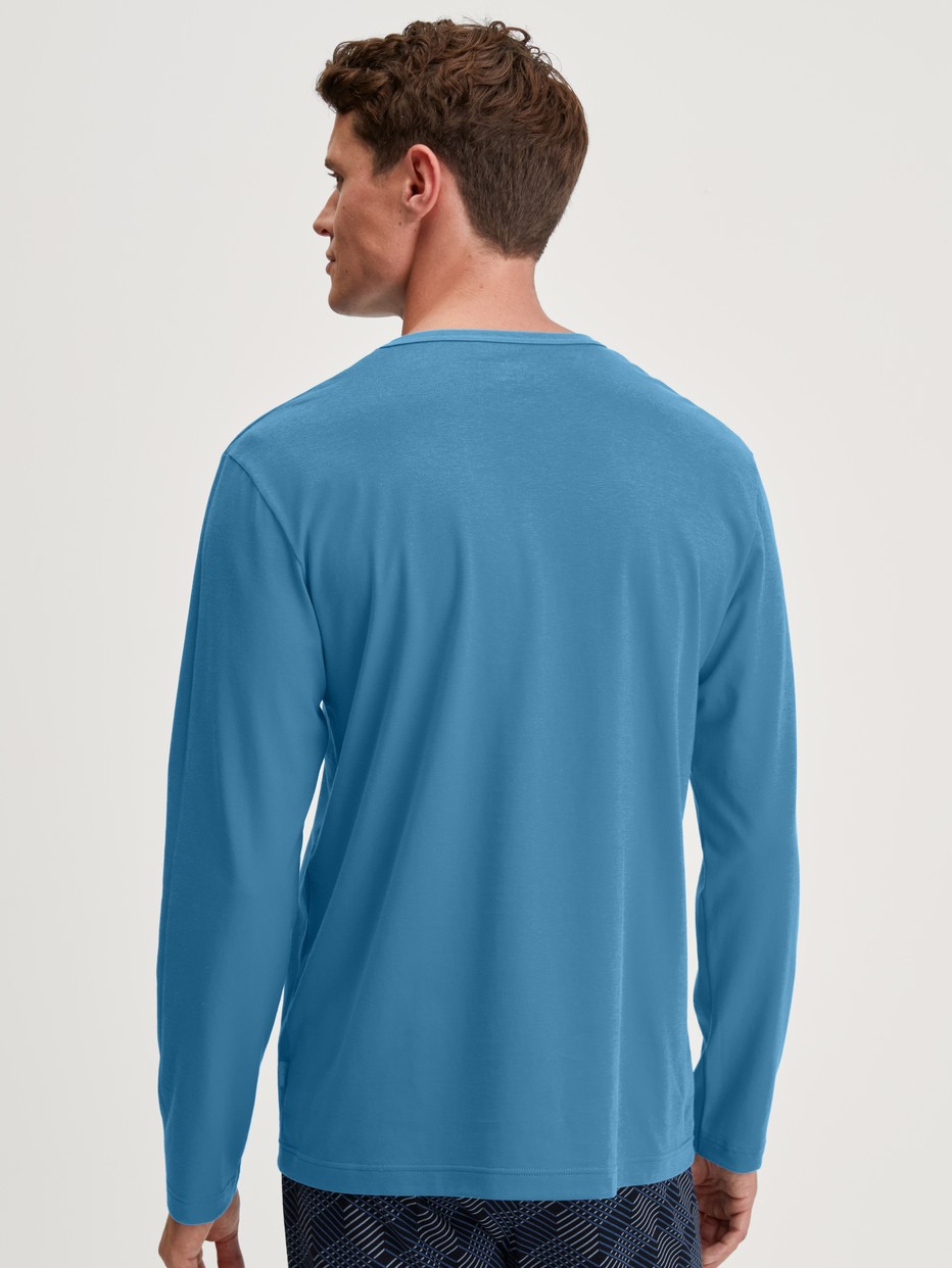 Herren-Model trägt Langarm-Shirt aus 100% Baumwolle in Blau, Einfarbig aus Serie RMX Sleep Leisure von CALIDA, Rückansicht