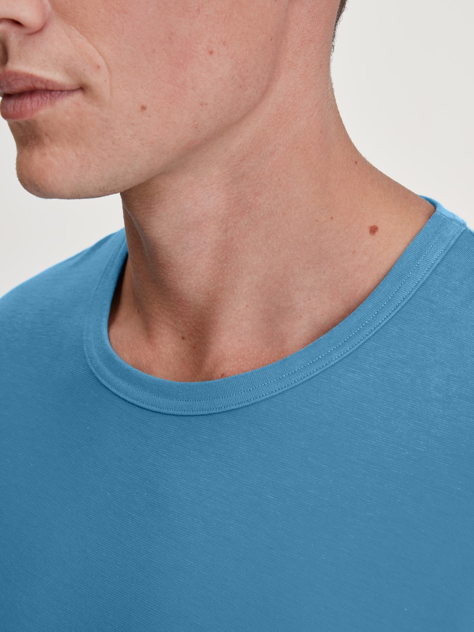 Herren-Model trägt Langarm-Shirt aus 100% Baumwolle in Blau, Einfarbig aus Serie RMX Sleep Leisure von CALIDA, Detail