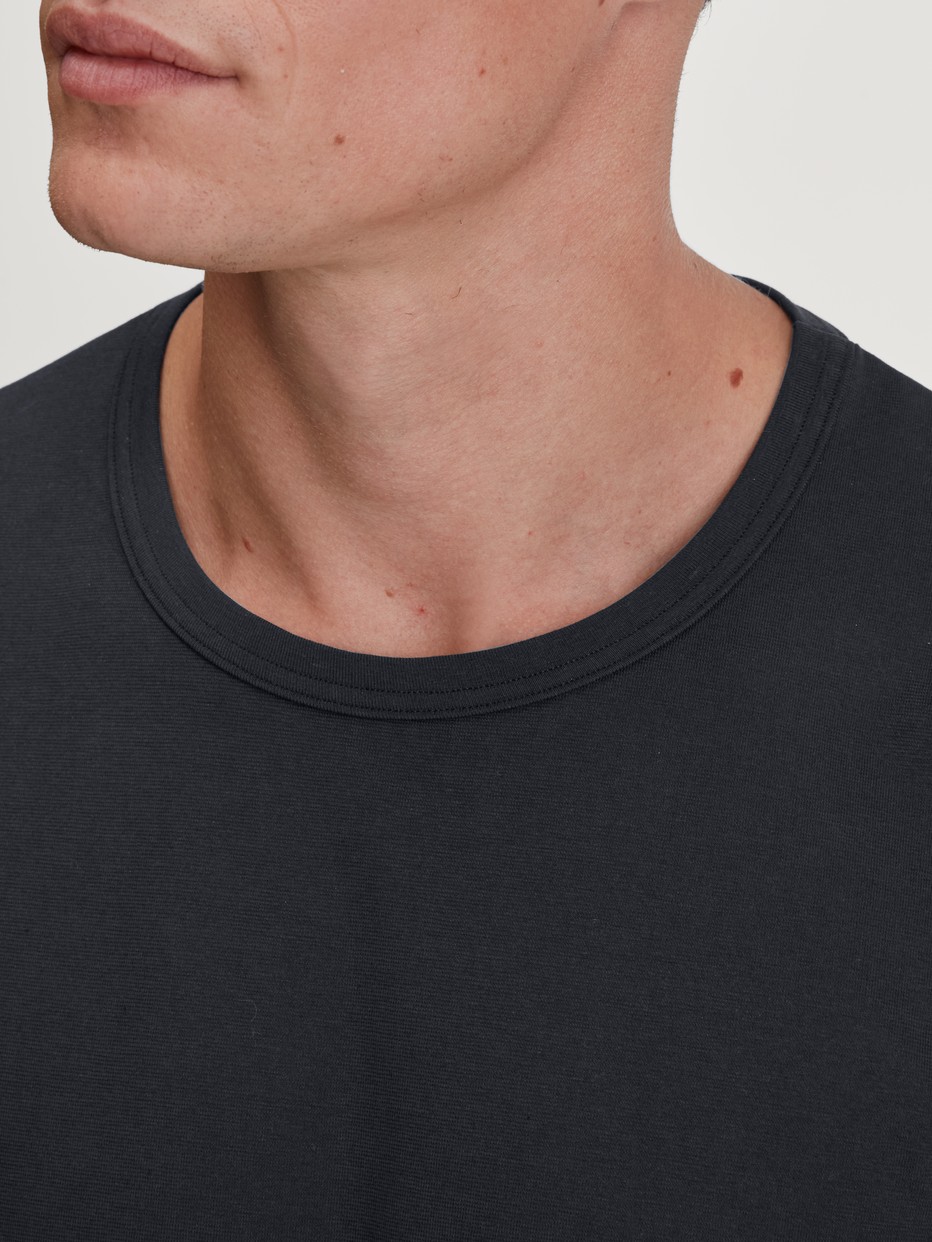 Men model is wearing Shirt long sleeve made of 100% Cotton in Black, Unicoloured from the RMX Sleep Leisure series by CALIDA, Detail