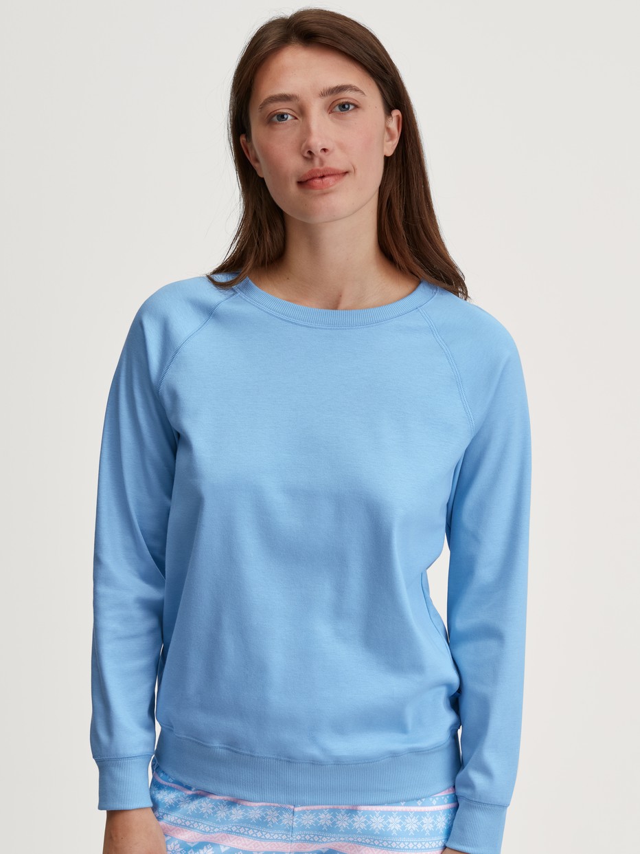 Women model is wearing Shirt long sleeve made of 100% Cotton in Blue, Unicoloured from the Ski Resort series by CALIDA, Front view