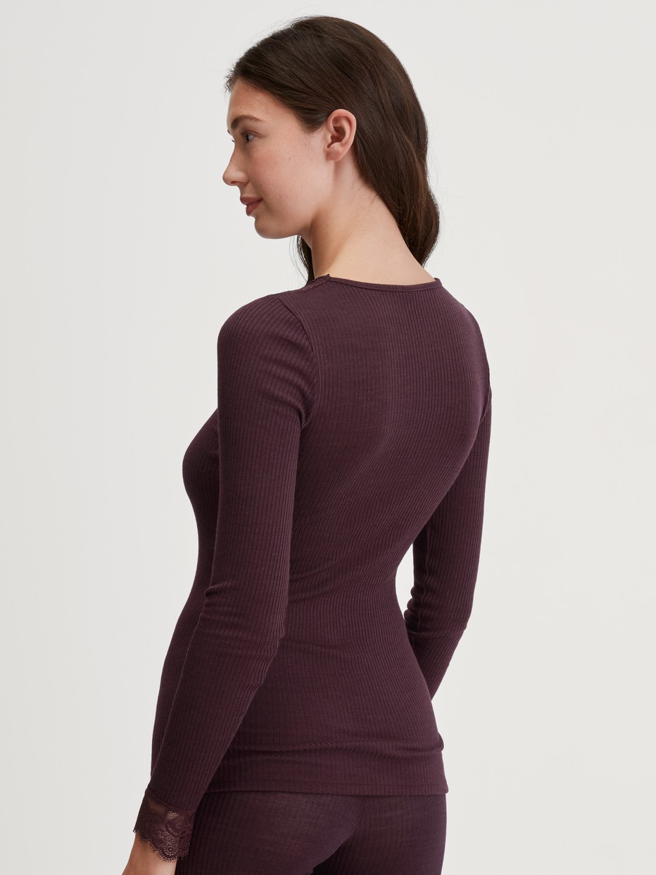 Damen-Model trägt Langarm-Shirt aus Wolle-Seide aus Wolle in Rot, Spitze aus Serie Silky Wool Joy von CALIDA, Rückansicht