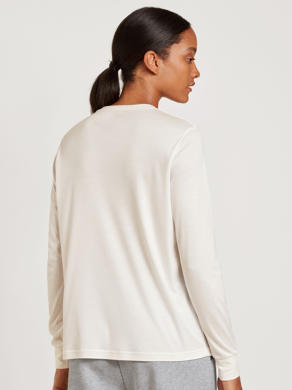 Damen-Model trägt Langarm-Shirt aus Modal in Weiß, Einfarbig aus Serie Lounge & Relax von CALIDA, Rückansicht