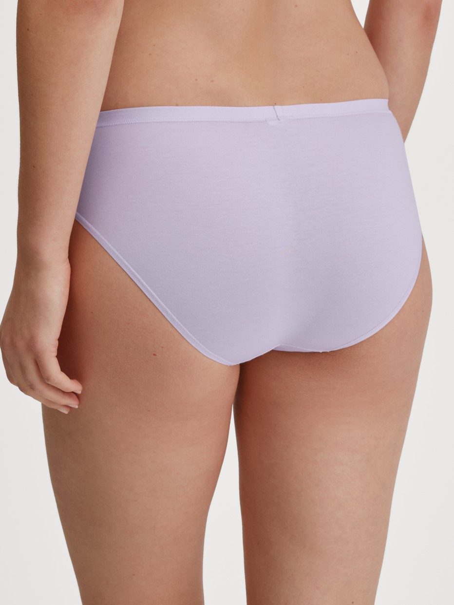 Damen-Model trägt Slip, regular cut aus Baumwolle in Violett, Einfarbig aus Serie Natural Comfort von CALIDA, Rückansicht