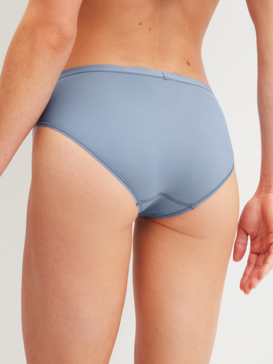 Damen-Model trägt Slip, regular cut aus Baumwolle in Blau, Einfarbig aus Serie Natural Comfort von CALIDA, Rückansicht