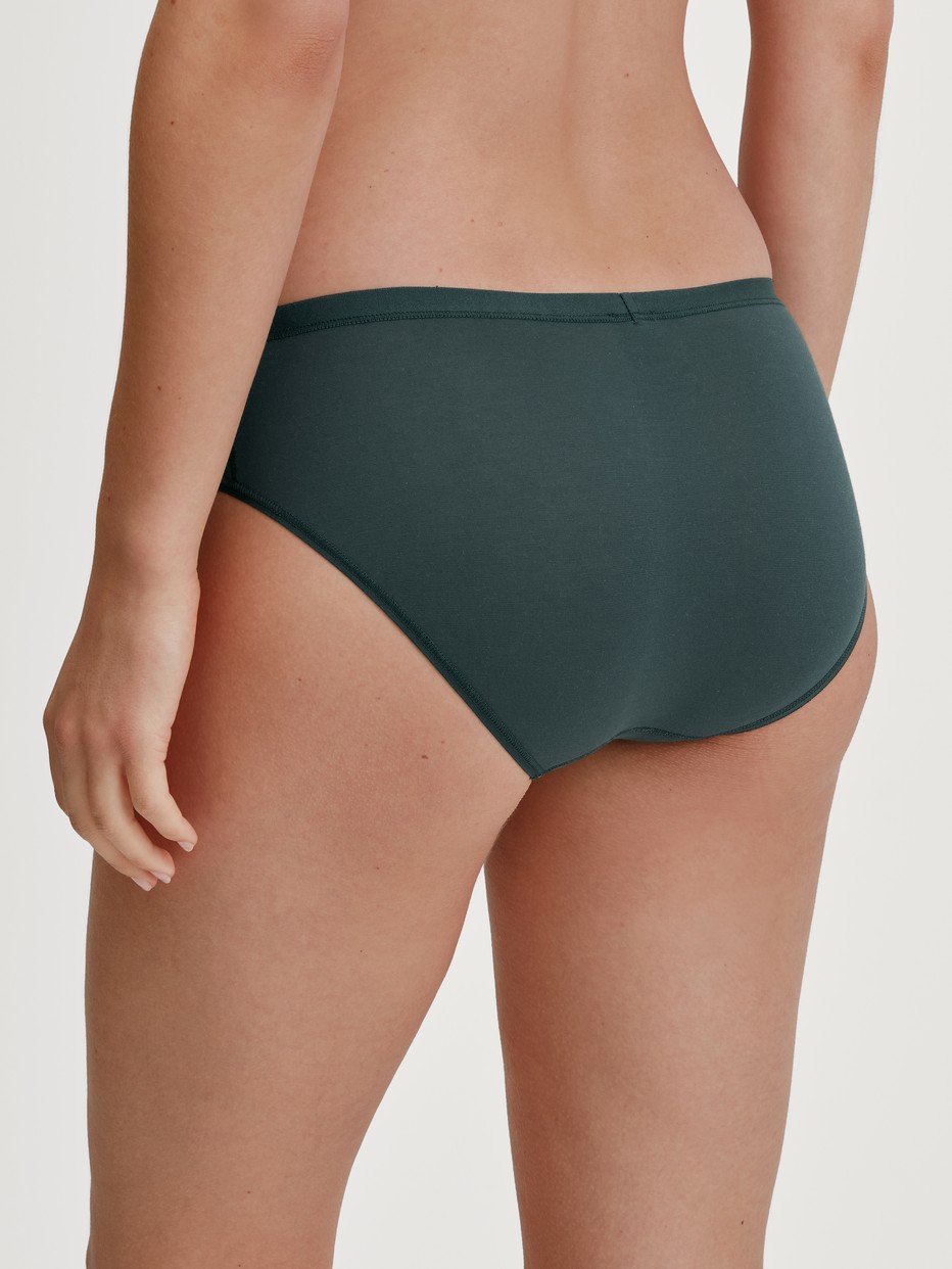 Damen-Model trägt Slip, regular cut aus Baumwolle in Grün, Einfarbig aus Serie Natural Comfort von CALIDA, Rückansicht