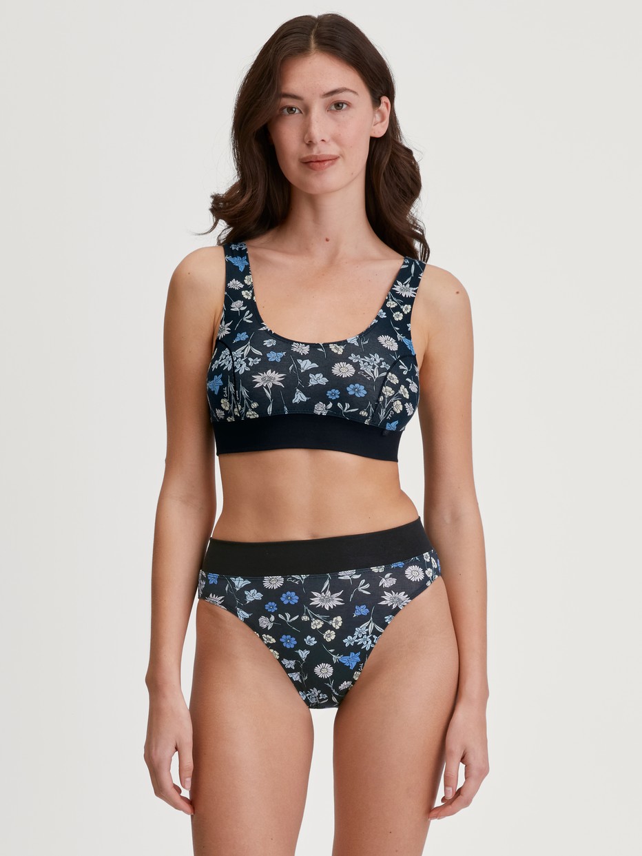Damen-Model trägt Slip mit Softbund, high waist aus Baumwolle in Schwarz, Floral aus Serie Elastic Trend von CALIDA, Outfit