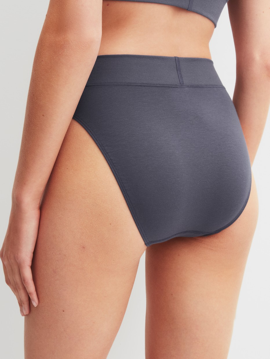 Damen-Model trägt Slip mit Softbund, high waist aus Baumwolle in Grau, Einfarbig aus Serie Elastic von CALIDA, Rückansicht