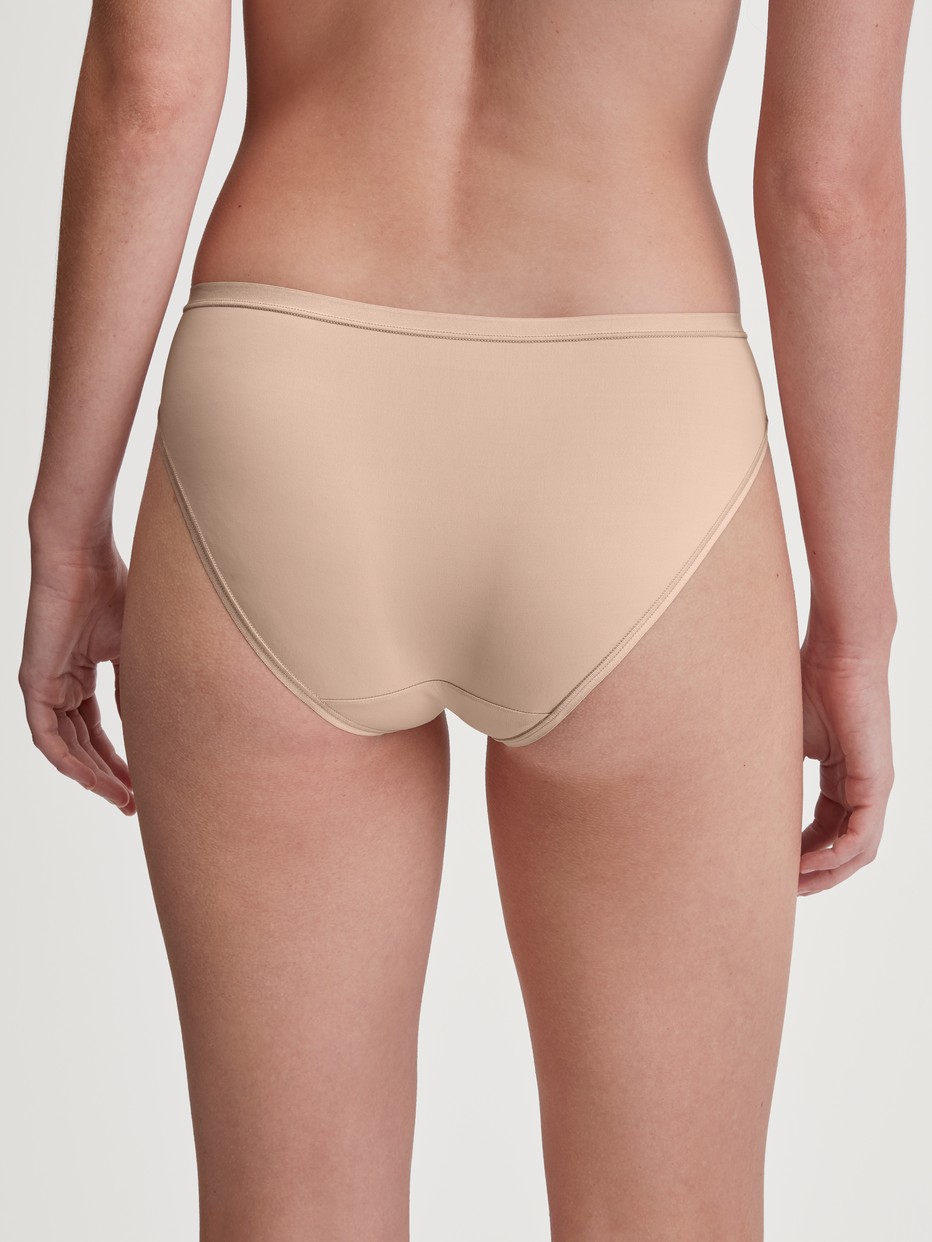 Damen-Model trägt Slip, regular cut aus Polyamid in Rosa, Einfarbig aus Serie Sleek Skin von CALIDA, Rückansicht
