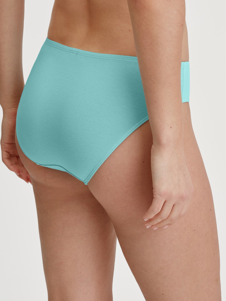 Damen-Model trägt Slip, regular cut aus Baumwolle in Türkis, Einfarbig aus Serie Nat. Comfort Xtra von CALIDA, Rückansicht
