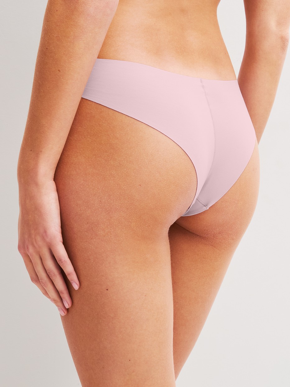 Women model is wearing Seamless Brazilian Brief made of Modal in Purple, Unicoloured from the Natural Skin series by CALIDA, Back view