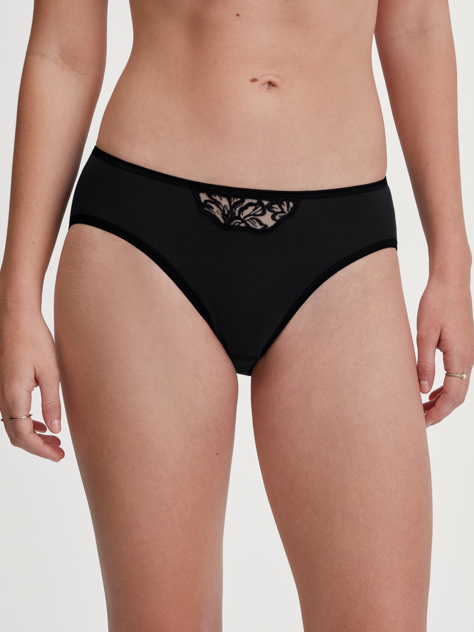 La modella / Il modello Donna indossa Slip mini in 100% cotone di colore Nero, Pizzo, della serie Cotton Desire di CALIDA, Vista frontale