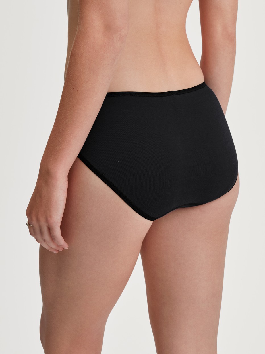 La modella / Il modello Donna indossa Slip mini in 100% cotone di colore Nero, Pizzo, della serie Cotton Desire di CALIDA, Vista posteriore