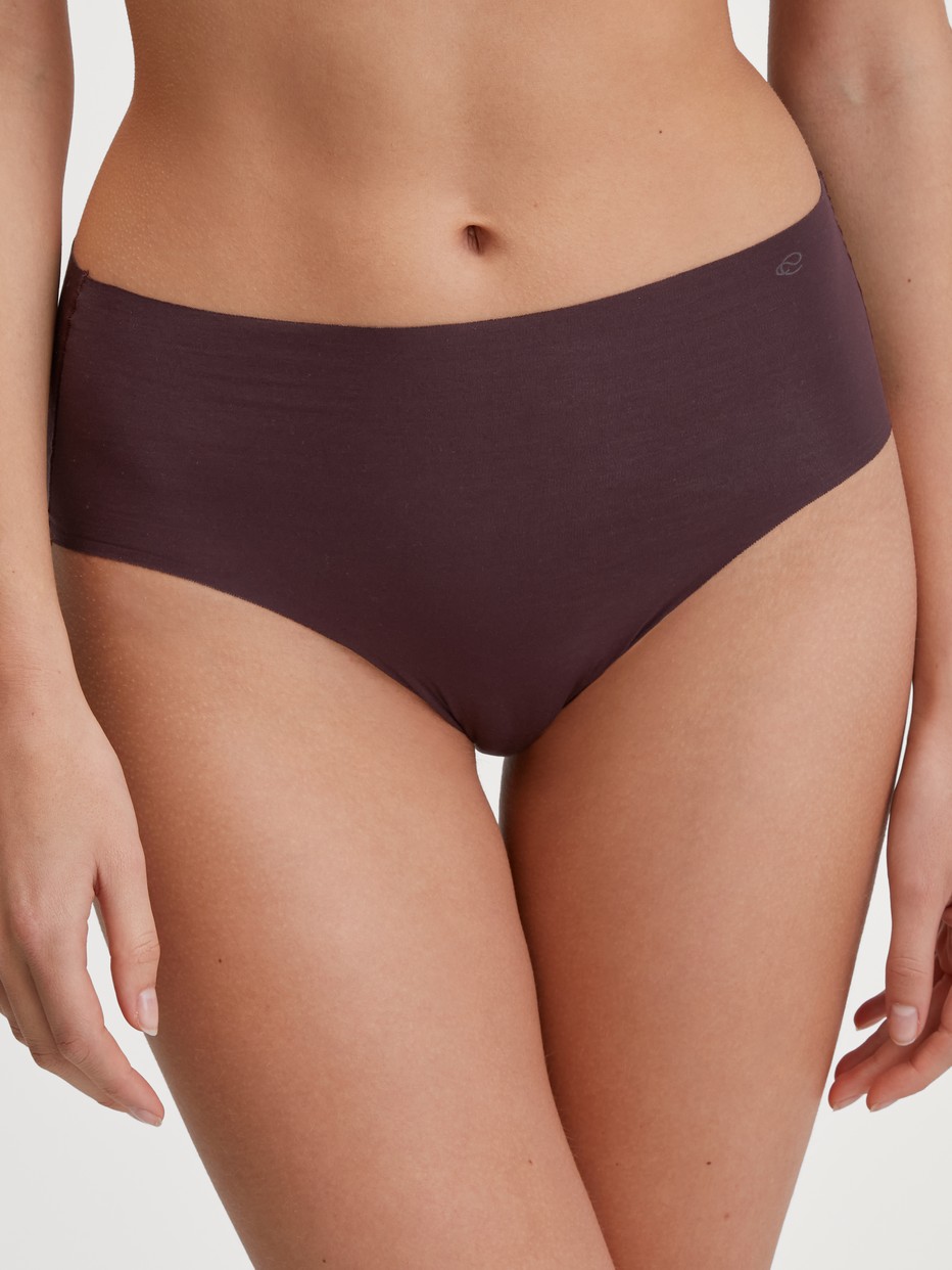 Damen-Model trägt Seamless-Midi-Slip aus Modal in Rot, Einfarbig aus Serie Natural Skin von CALIDA, Vorderansicht
