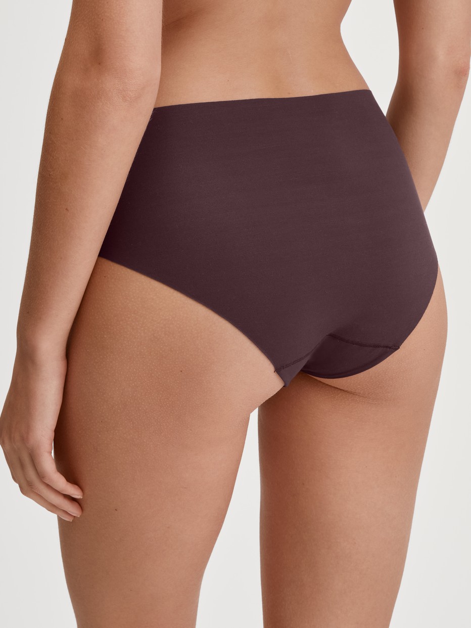 Damen-Model trägt Seamless-Midi-Slip aus Modal in Rot, Einfarbig aus Serie Natural Skin von CALIDA, Rückansicht