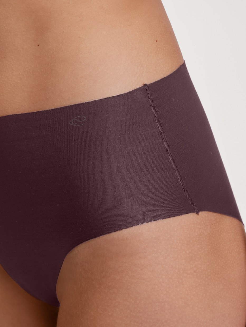 Damen-Model trägt Seamless-Midi-Slip aus Modal in Rot, Einfarbig aus Serie Natural Skin von CALIDA, Detail