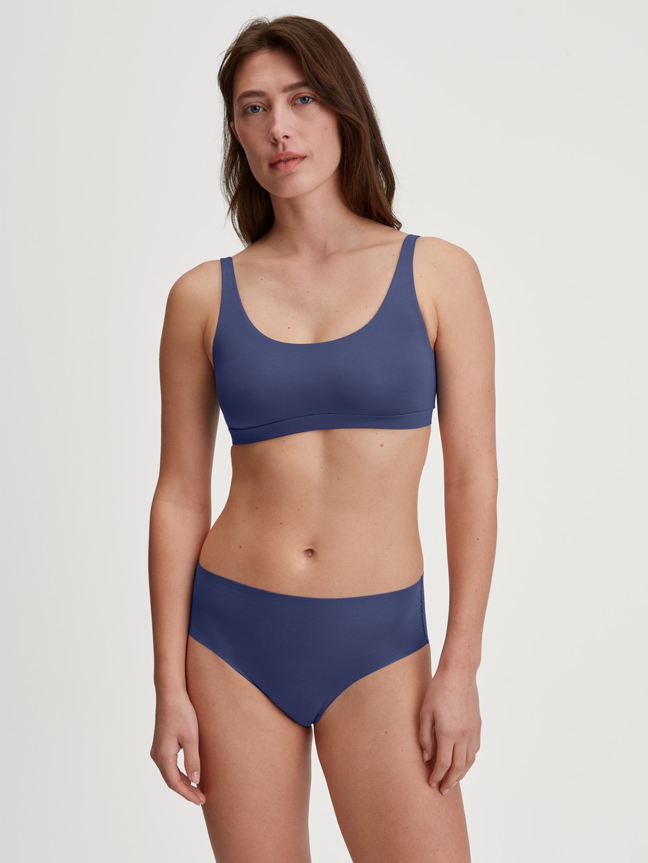 Damen-Model trägt Seamless-Midi-Slip aus Modal in Blau, Einfarbig aus Serie Natural Skin von CALIDA, Outfit