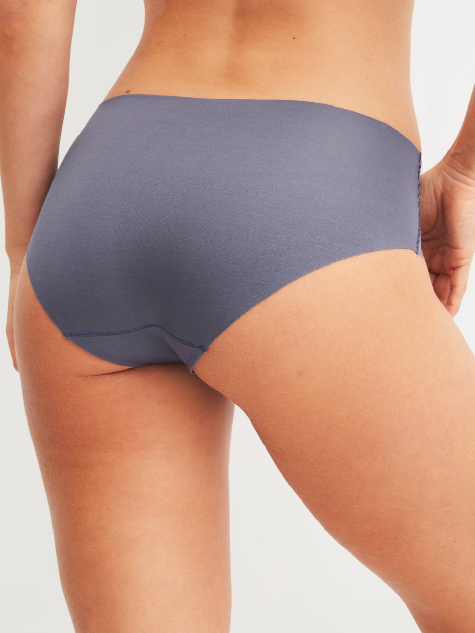 Damen-Model trägt Seamless-Midi-Slip aus Modal in Grau, Einfarbig aus Serie Natural Skin von CALIDA, Rückansicht