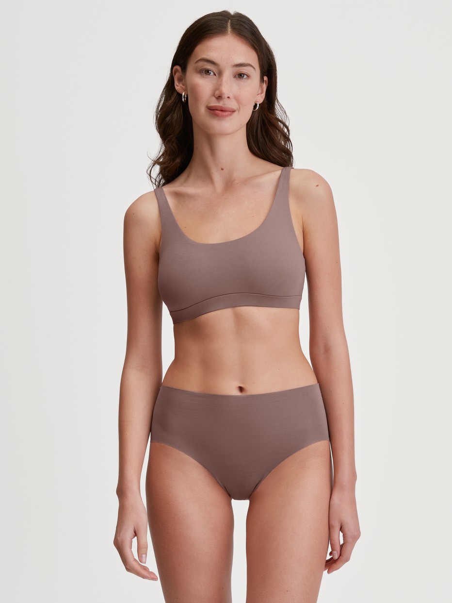 Damen-Model trägt Seamless-Midi-Slip aus Modal in Braun, Einfarbig aus Serie Natural Skin von CALIDA, Outfit