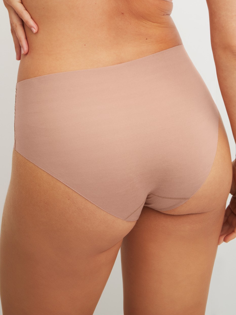 Damen-Model trägt Seamless-Midi-Slip aus Modal in Braun, Einfarbig aus Serie Natural Skin von CALIDA, Rückansicht