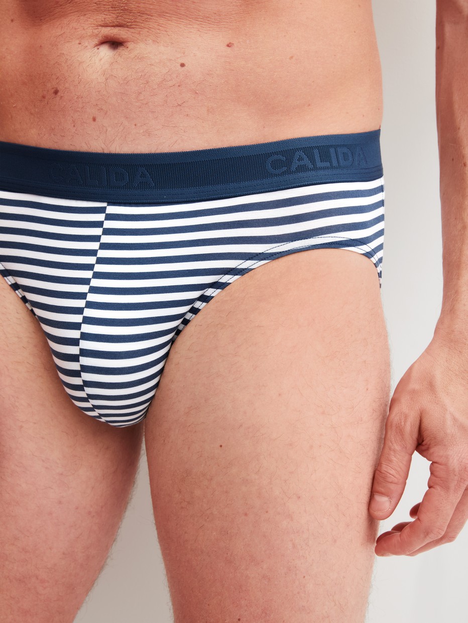 La modella / Il modello Uomo indossa Slip in Cotone di colore Blu, A righe, della serie Grafic Cotton di CALIDA, Dettaglio