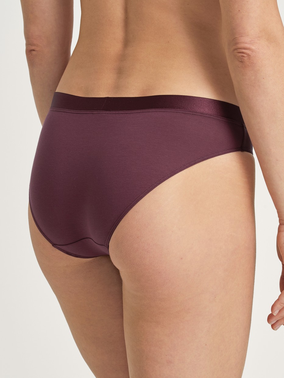 Damen-Model trägt Slip aus Baumwolle in Rot, Einfarbig aus Serie Cate von CALIDA, Rückansicht