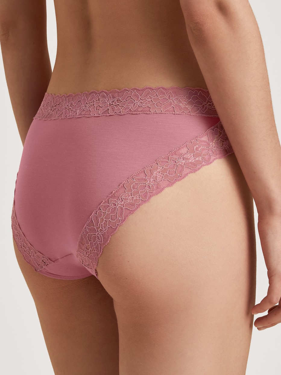 Damen-Model trägt Slip, regular cut aus Baumwolle in Rosa, Spitze aus Serie Nat. Comfort Xtra von CALIDA, Rückansicht