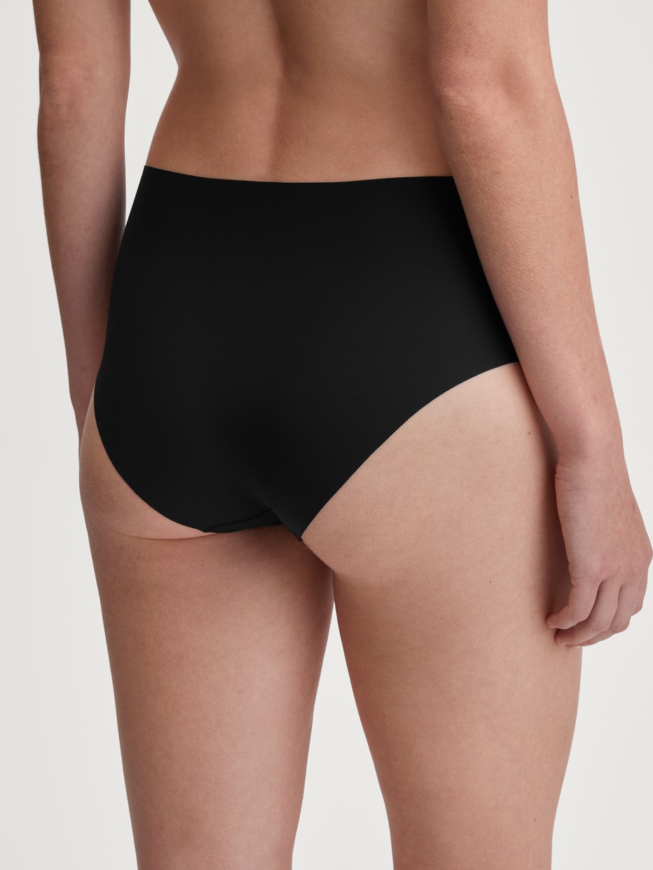 Damen-Model trägt Panty, low cut aus Polyamid in Schwarz, Einfarbig aus Serie Sleek Skin von CALIDA, Rückansicht