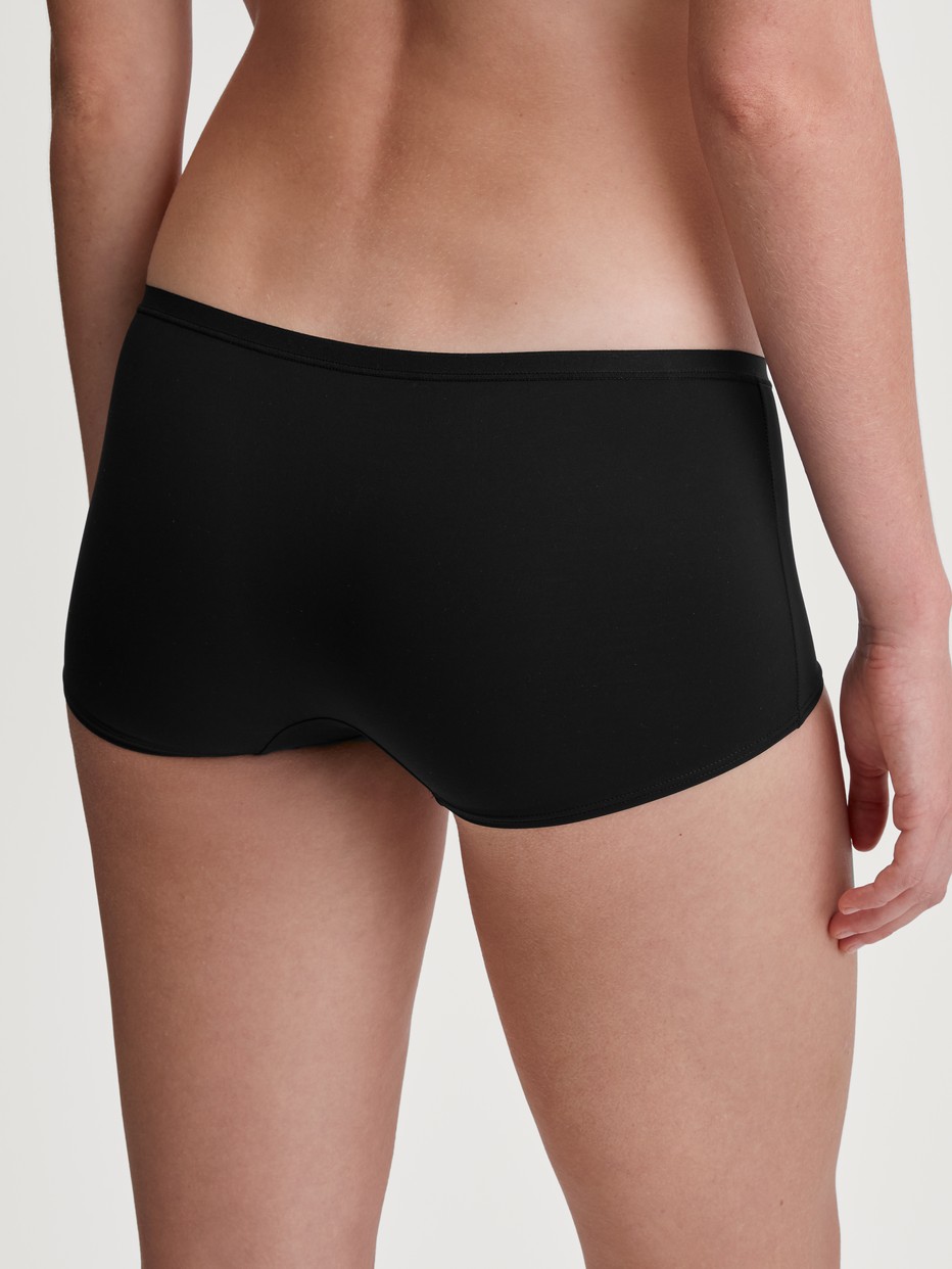 Damen-Model trägt Panty, regular cut aus Polyamid in Schwarz, Einfarbig aus Serie Sleek Skin von CALIDA, Rückansicht
