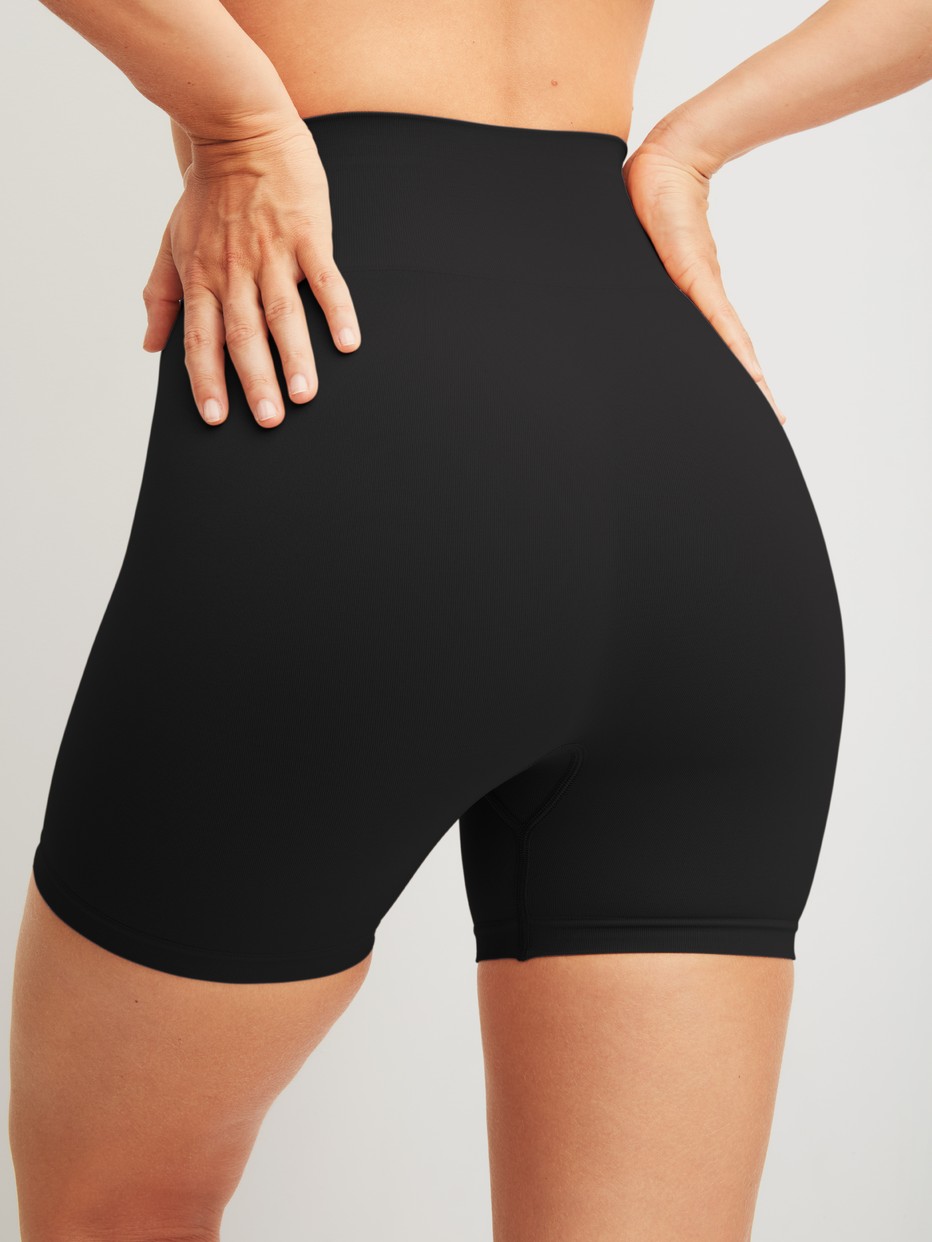 La modella / Il modello Donna indossa Pantaloncino modellante in Poliammide di colore Nero, Tinta unita, della serie Seamless Shape di CALIDA, Vista posteriore