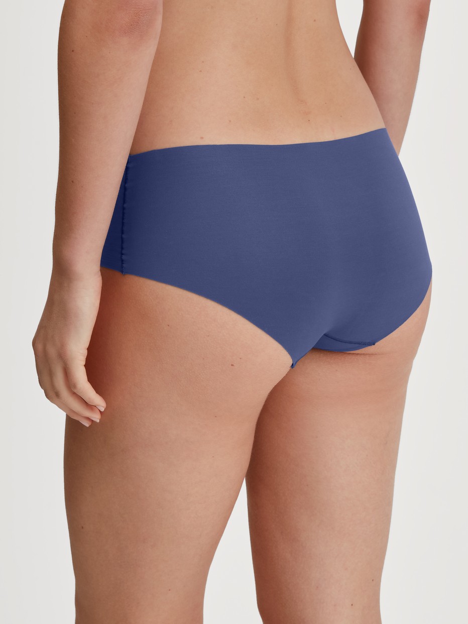 Damen-Model trägt Seamless-Panty, low cut aus Modal in Blau, Einfarbig aus Serie Natural Skin von CALIDA, Rückansicht